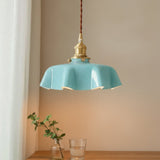 Turquoise pendant light with gold fixture on a neutral background