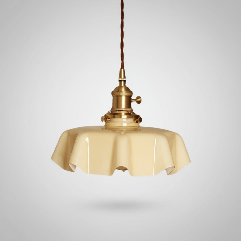 Vintage-style pendant light with beige glass shade and brass fixture on a gray background