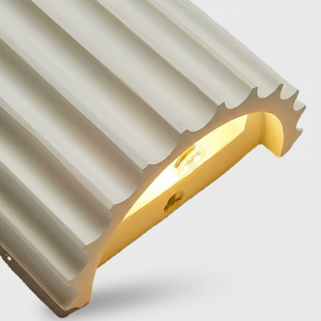 Close-up of a metallic architectural element with a ribbed surface on a light gray background