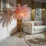 Modern living room with a pink feathered floor lamp, white sofa, and decorative wall art.