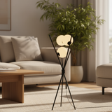 Modern floor lamp in a living room setting with a sofa and plant.