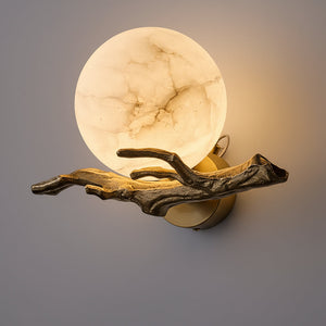 Decorative wall light fixture with marble-like finish and branch-like design on a gray background