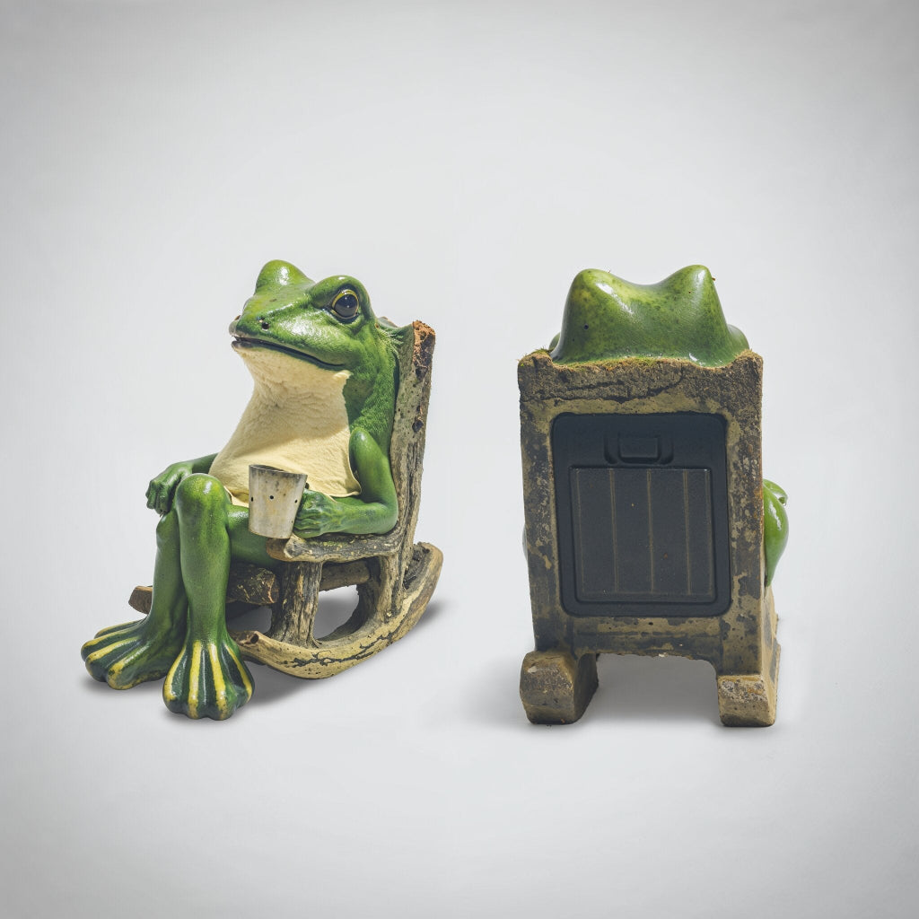 Frog figurine sitting on a chair with a cup and a solar panel on a white background