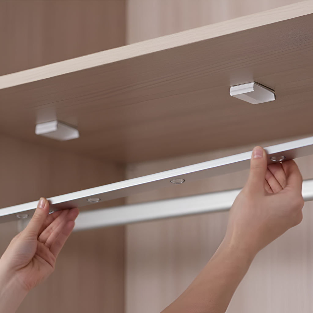 Person installing a light strip on a wooden shelf.