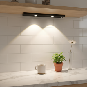 Modern kitchen setup with a light fixture, plant, and mug on a countertop.