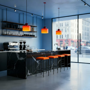 Modern kitchen with marble island, orange pendant lights, and cityscape view.