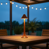 Outdoor table lamp on a wooden table with string lights in the background