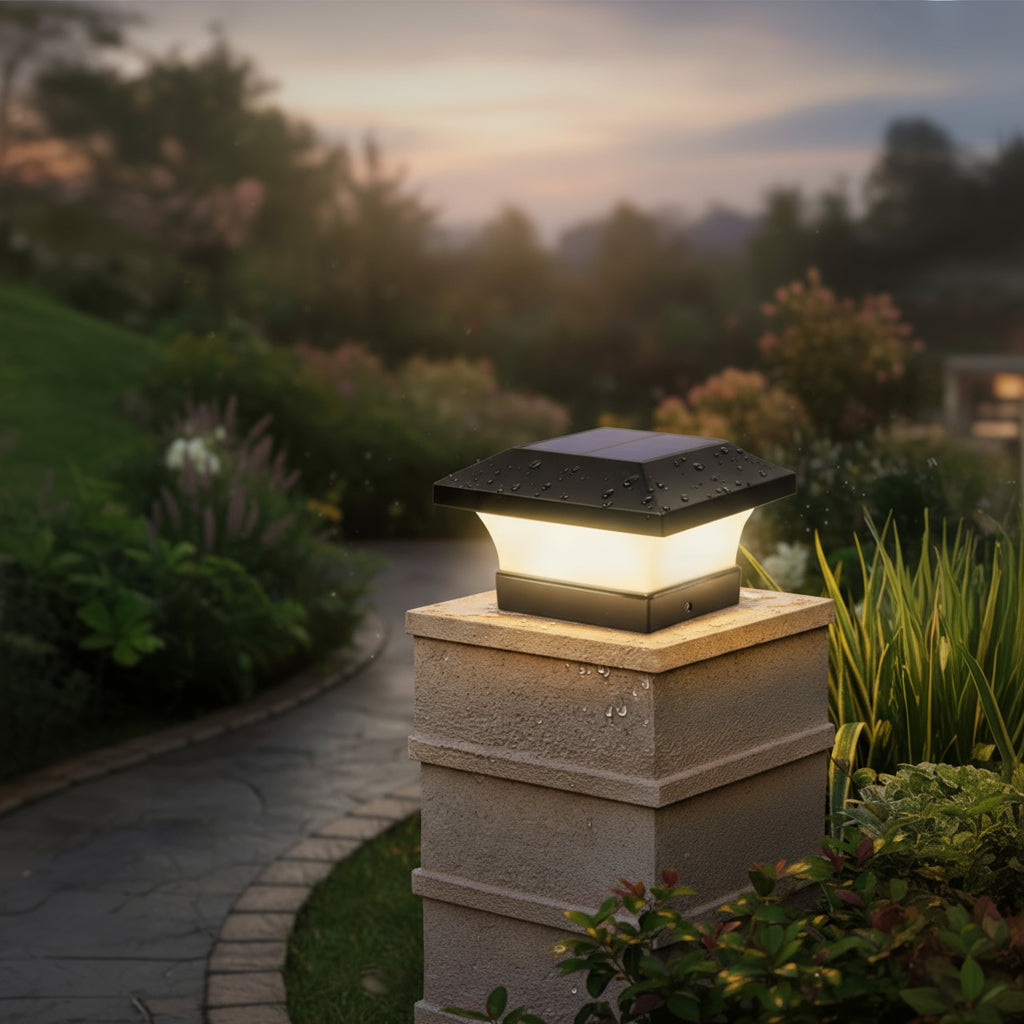 Garden light fixture on a stone post with a blurred garden background