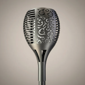 Decorative metal spoon with intricate cut-out design on a beige background